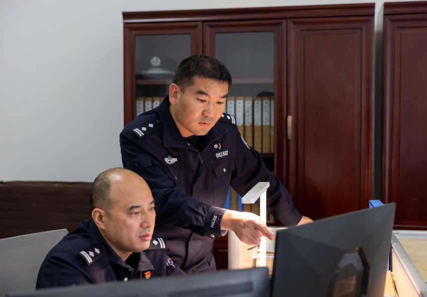 刘定伟正在与法制审核民警研判疑难案件。资阳市公安局供图