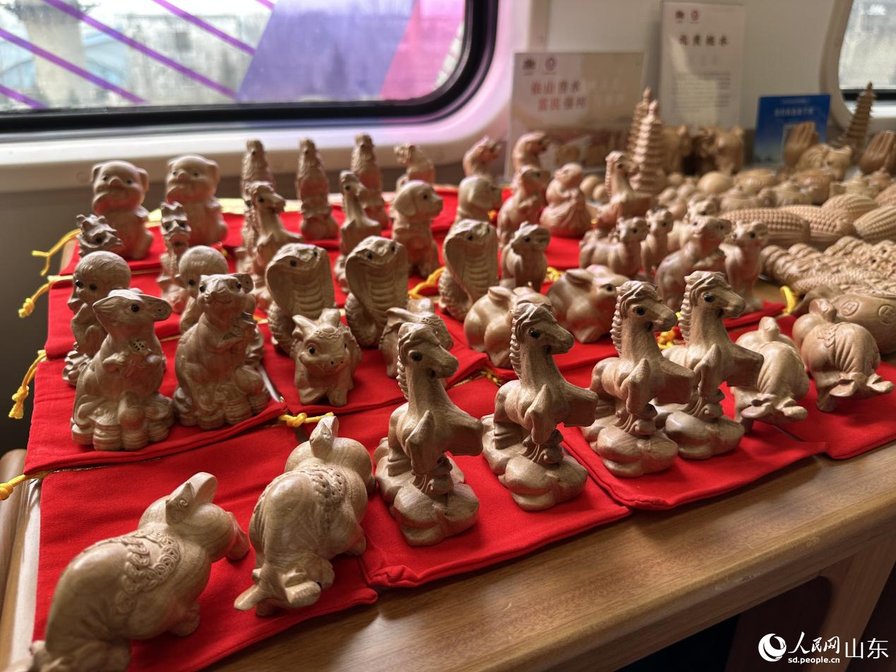 1月29日，在“齐鲁1号·黄河大集”主题车厢内展示桃木雕刻工艺品。人民网记者 乔姝摄